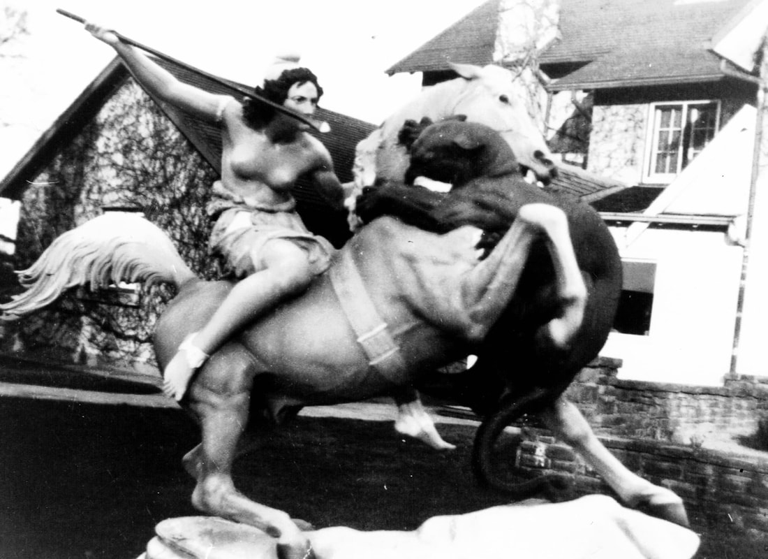 Photo of ‘Lady Guinevere’ statue, a bare-chested Amazonian with a spear sitting on a horse and being attacked by a dragon.