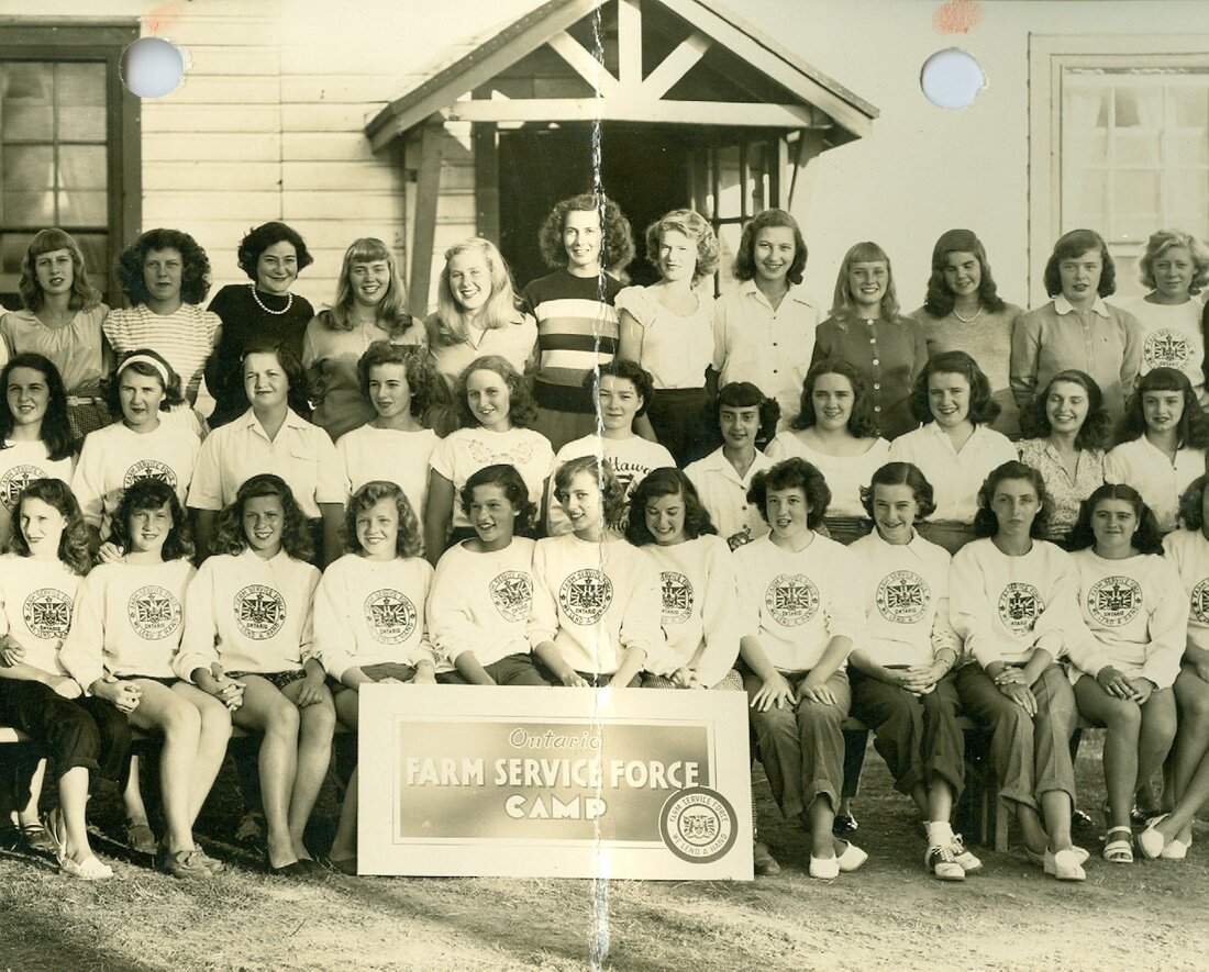 Black and white photograph of three rows of girls in front of building